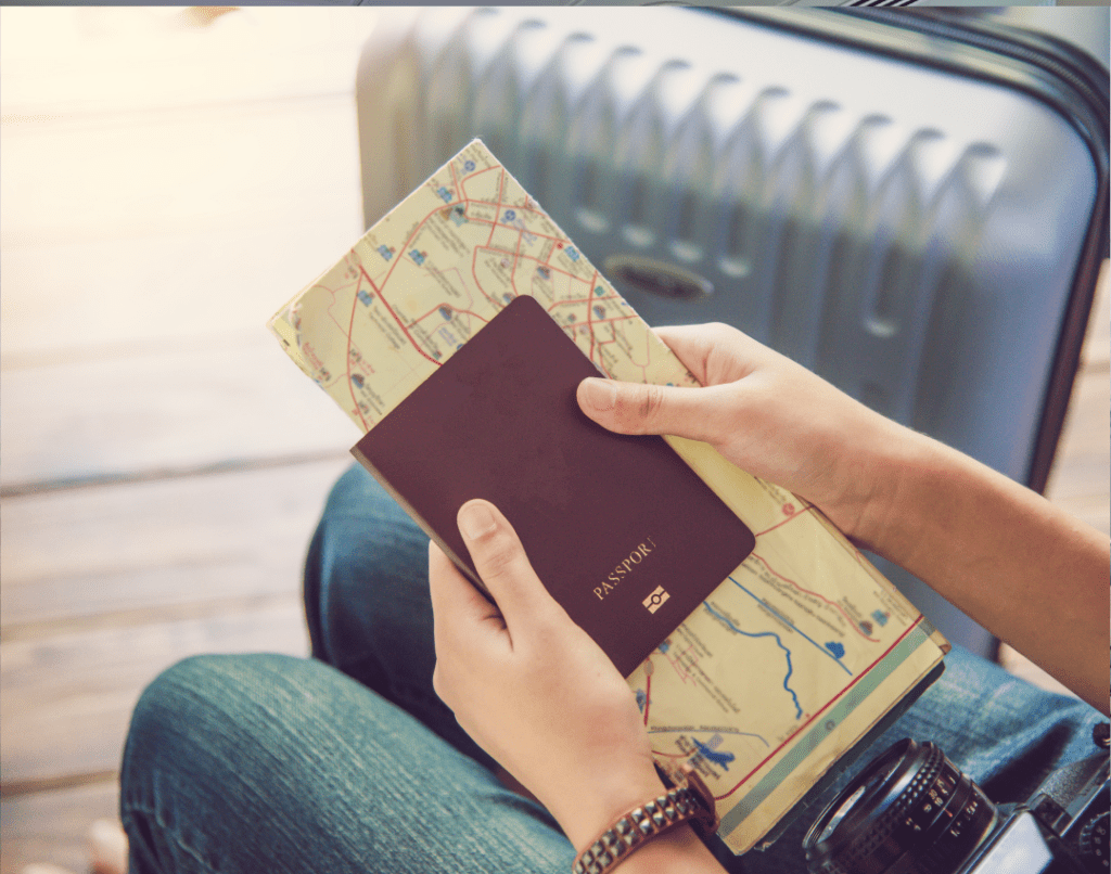 Woman sitting with passport, map and suitcase