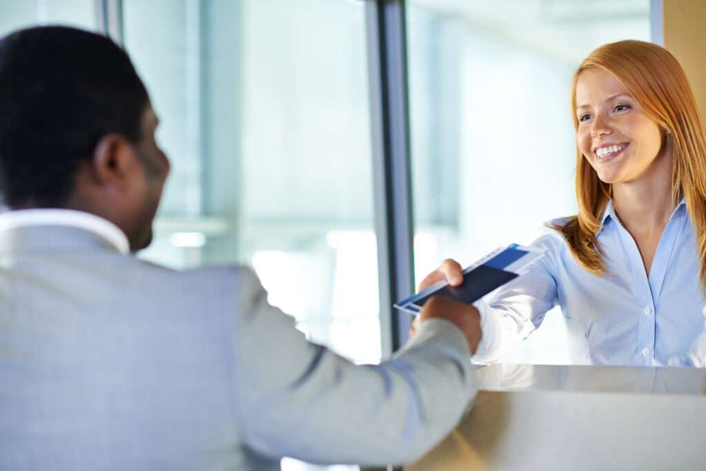 Woman handing man plane tickets and passport