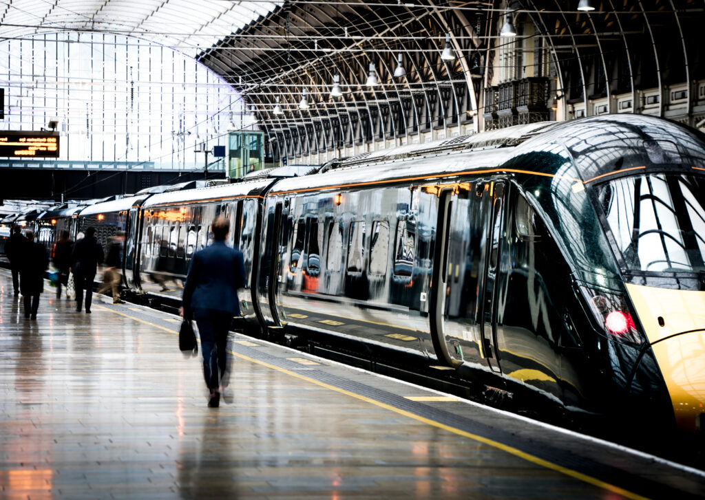 Man walking towards a train at a platform ready to board